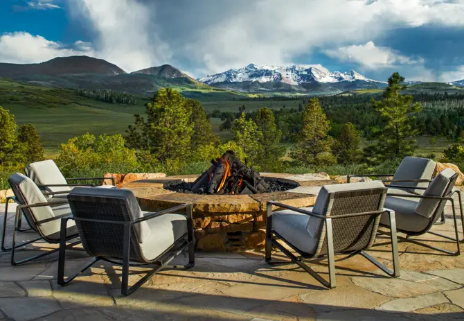 chairs surrounding a firepit looking into the open fields and mountain