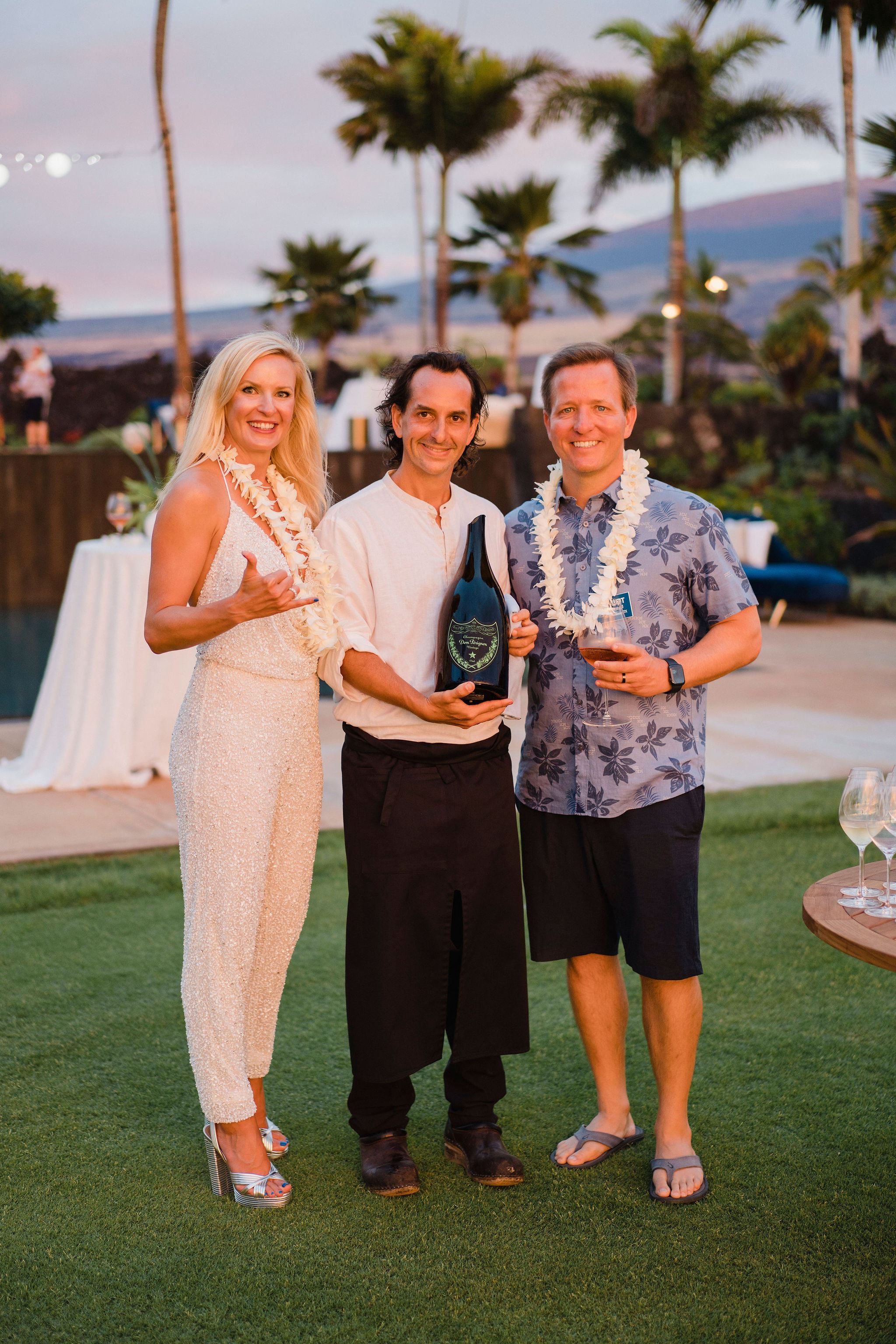 people in hawaiin attire greeting and looking at the camera